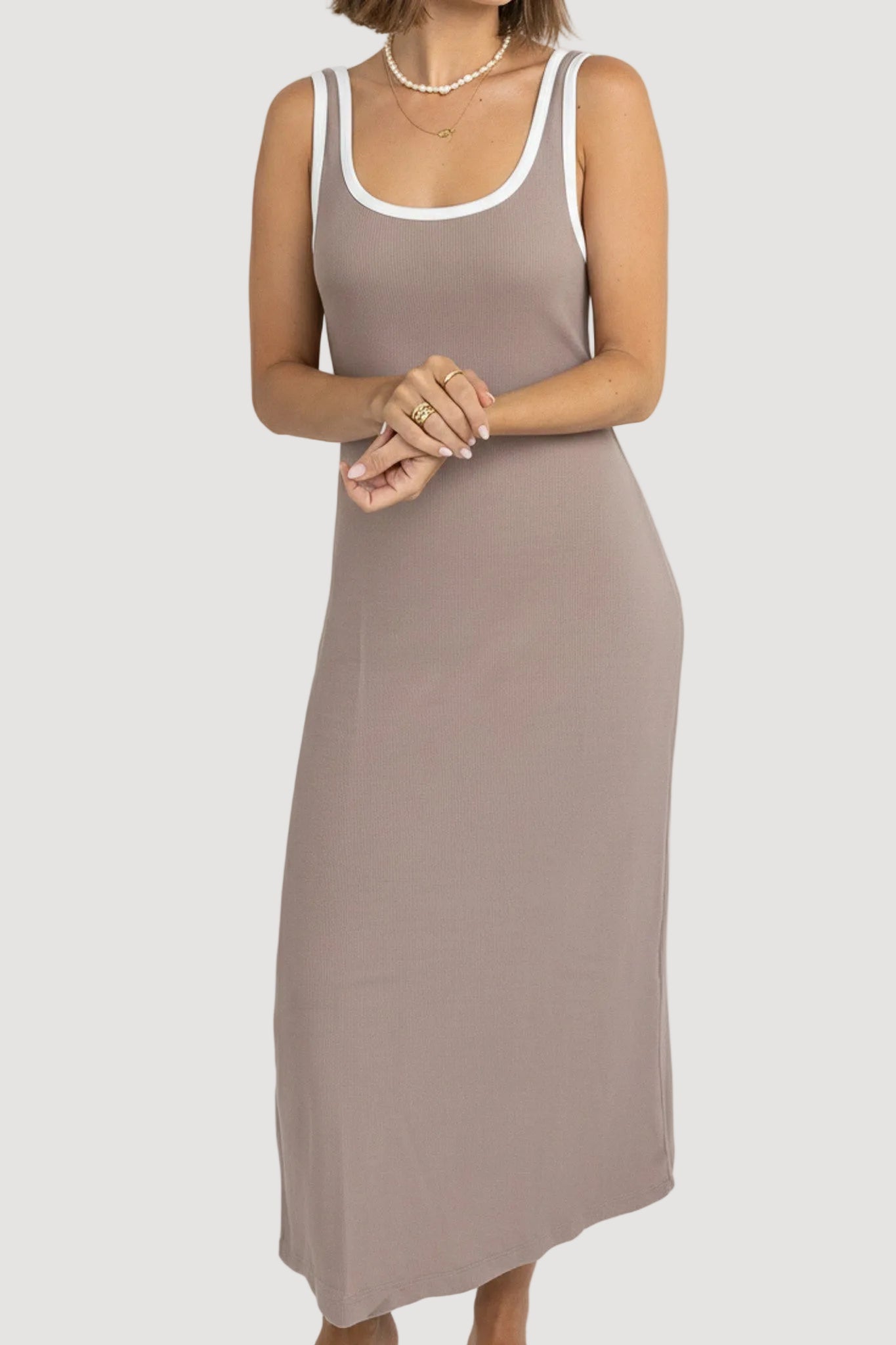 Woman wearing a beige sleeveless dress on a white background