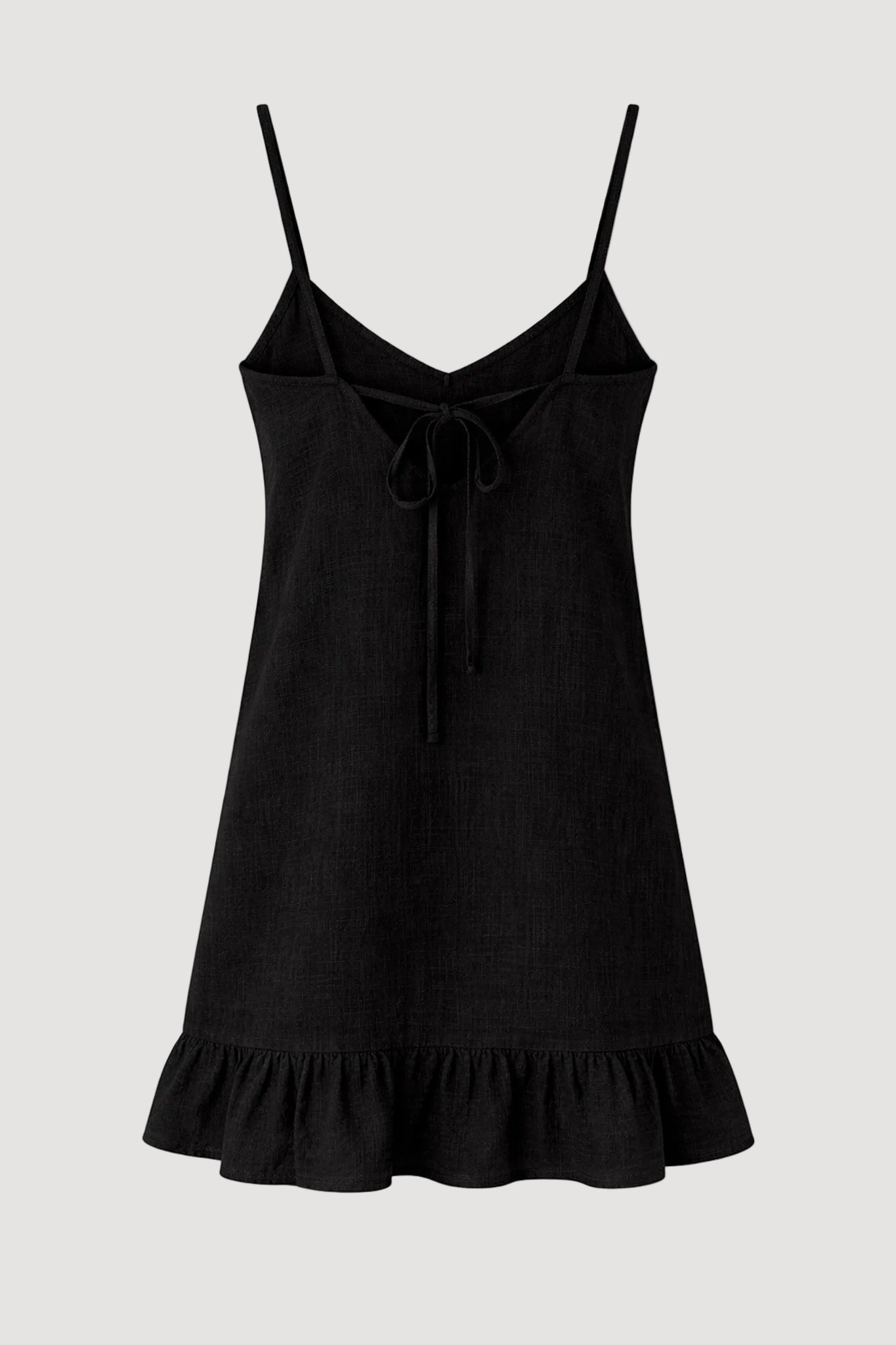 Black slip dress with ruffled hem on a white background