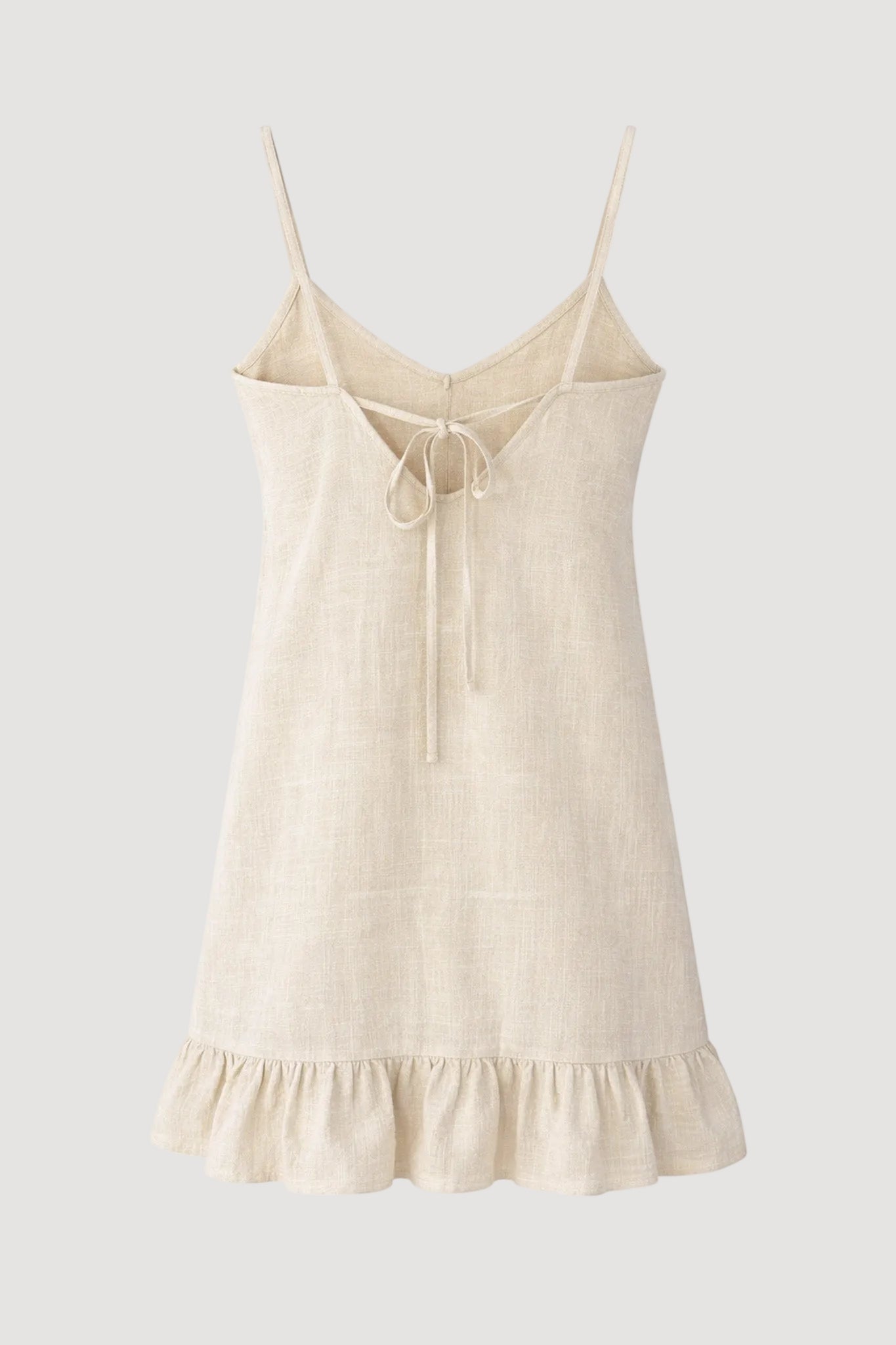 Beige slip dress with thin straps on a white background