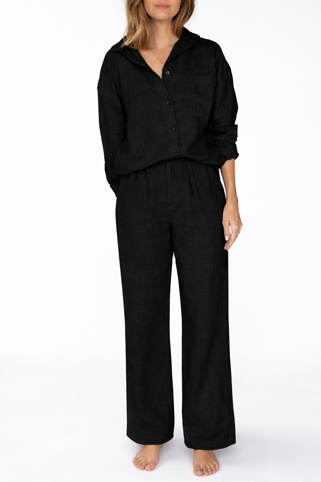 Woman wearing a black pajama set on a white background