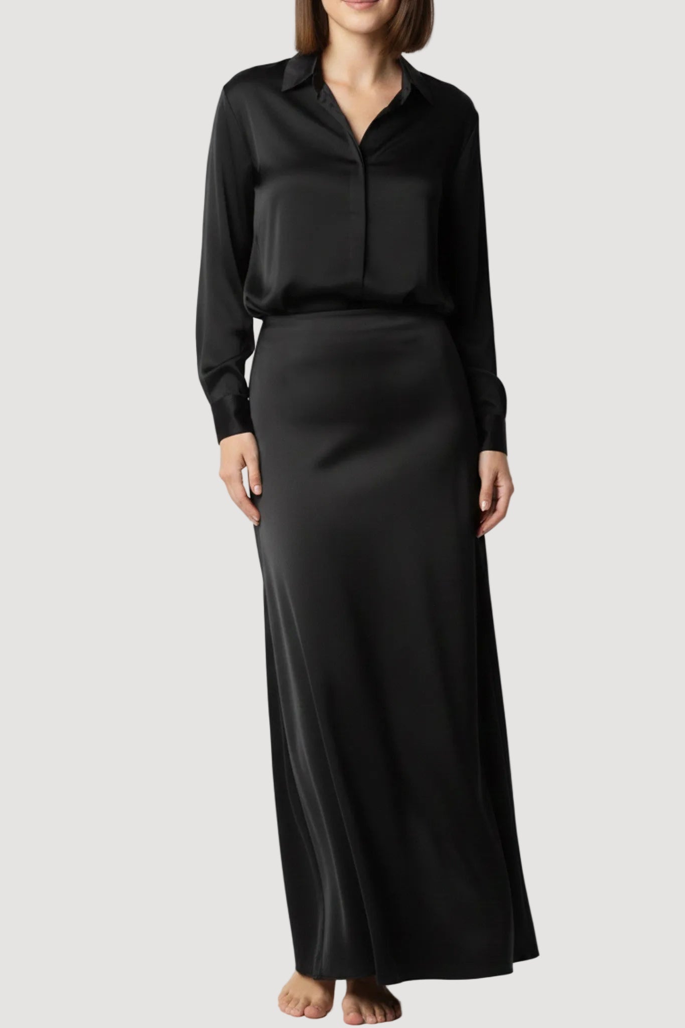Person wearing a black outfit with a long skirt on a white background