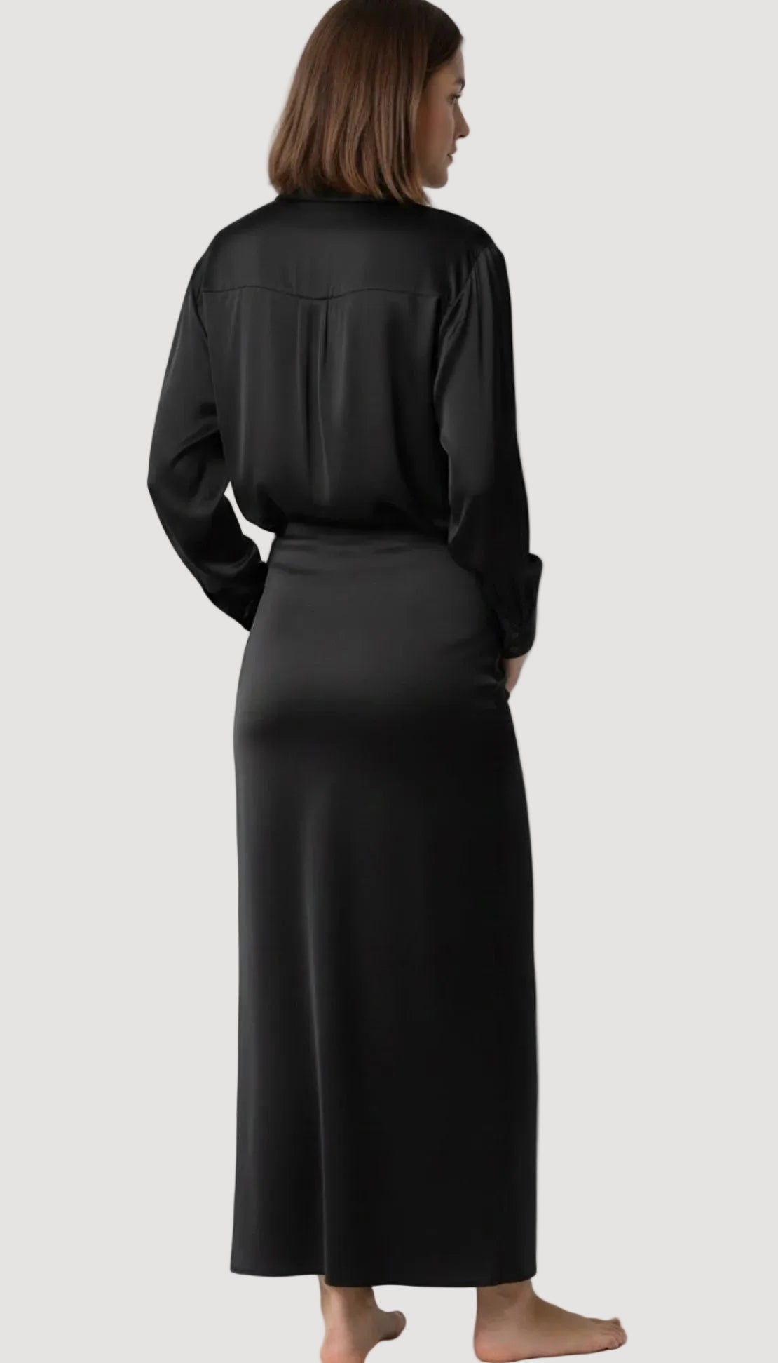 Person wearing a black outfit with a long skirt on a white background