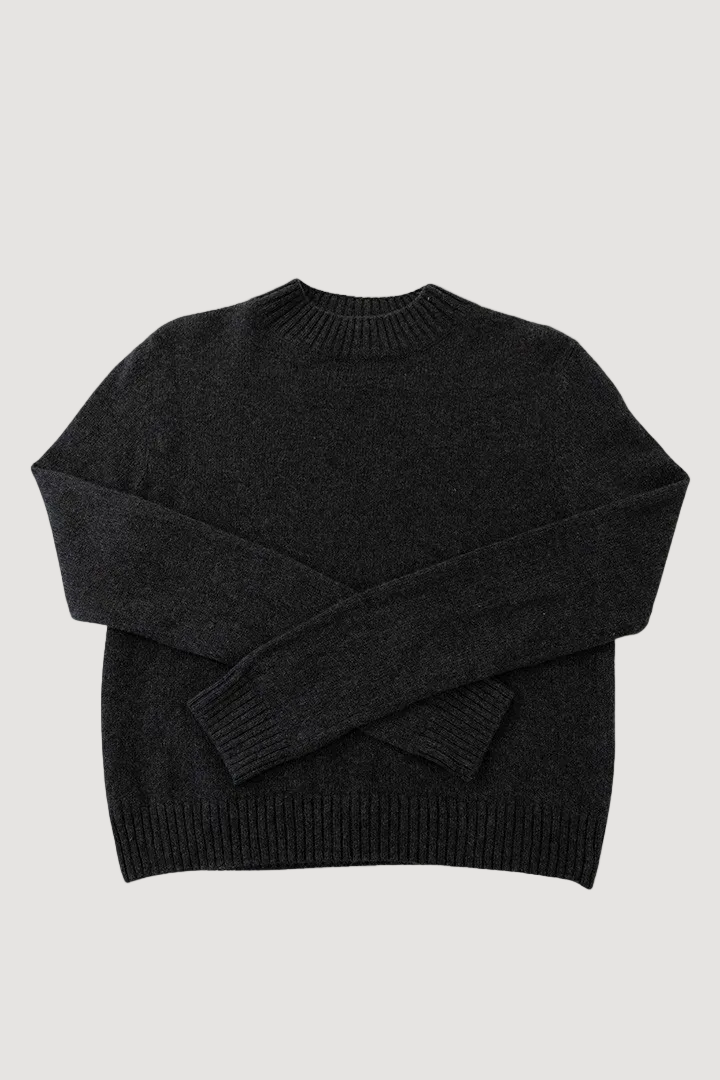 A dark grey mock neck sweater laid flat against a white background, showing the rib-knitted detailing on the collar, cuffs, and hem.