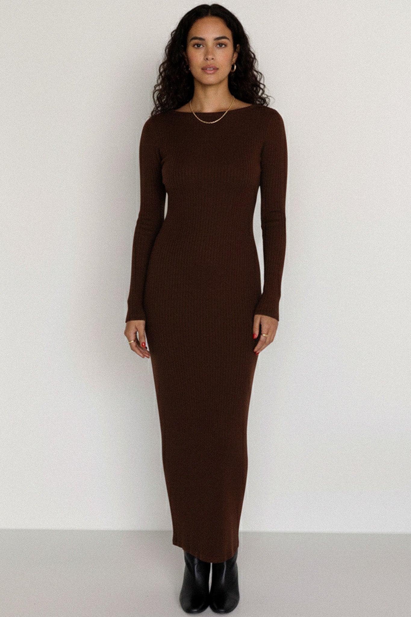 Woman wearing a brown long-sleeve dress against a white background