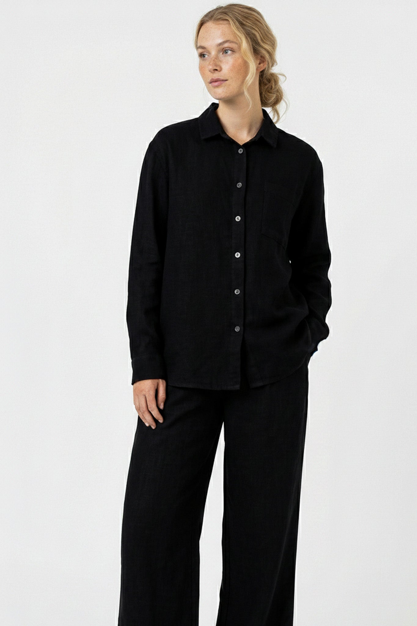 Woman wearing a black shirt and pants on a white background