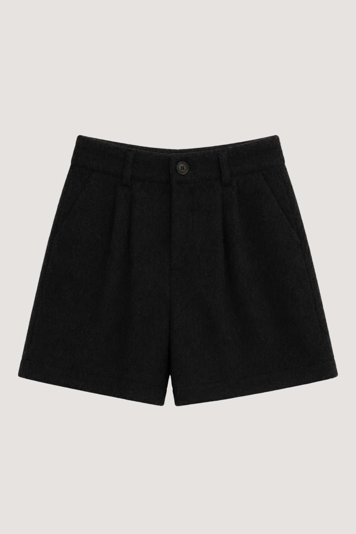 Black pleated wool shorts with a single button closure, laid flat on a light beige background.