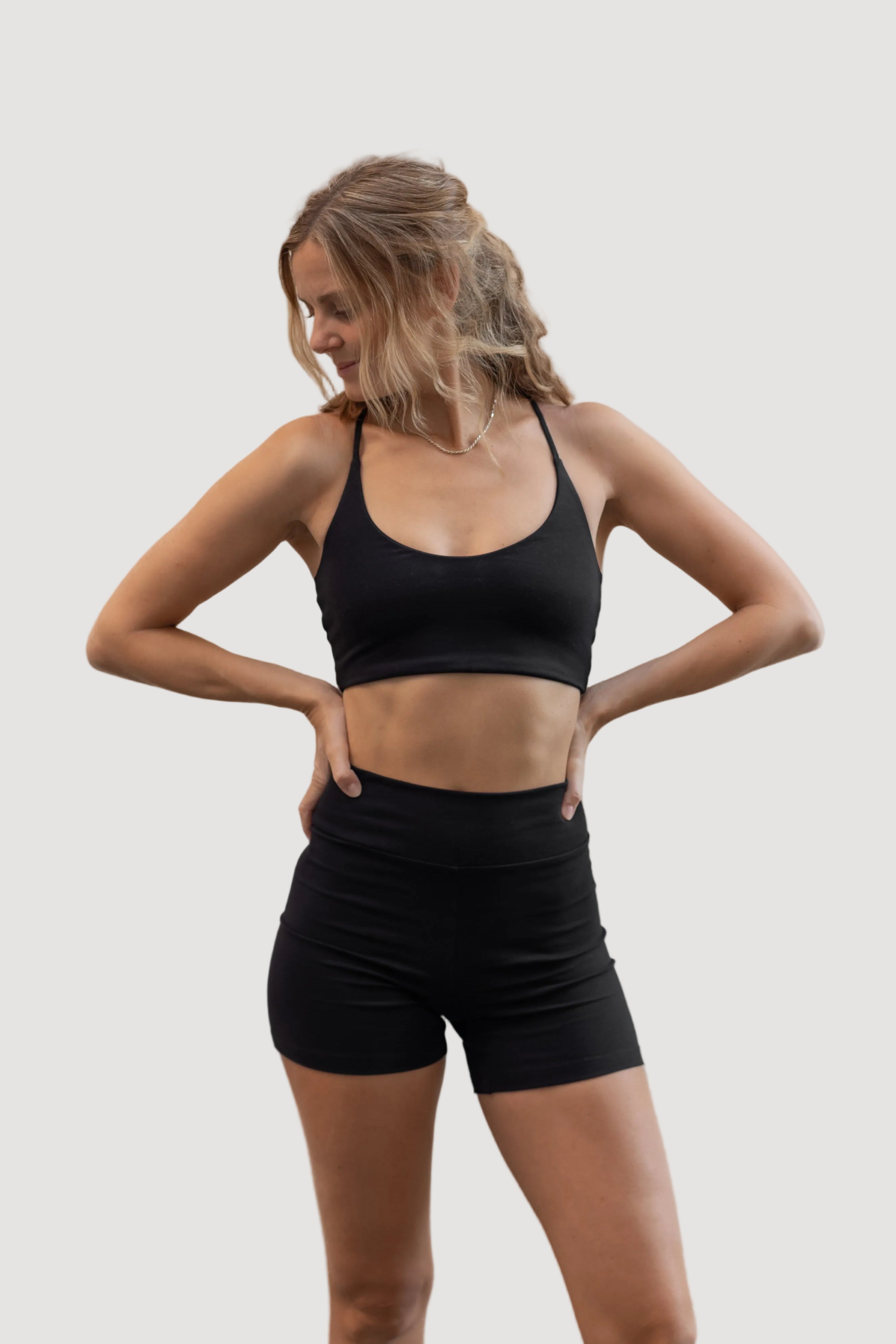 A female model wearing a black Tencel top and matching shorts, standing against a neutral background.
