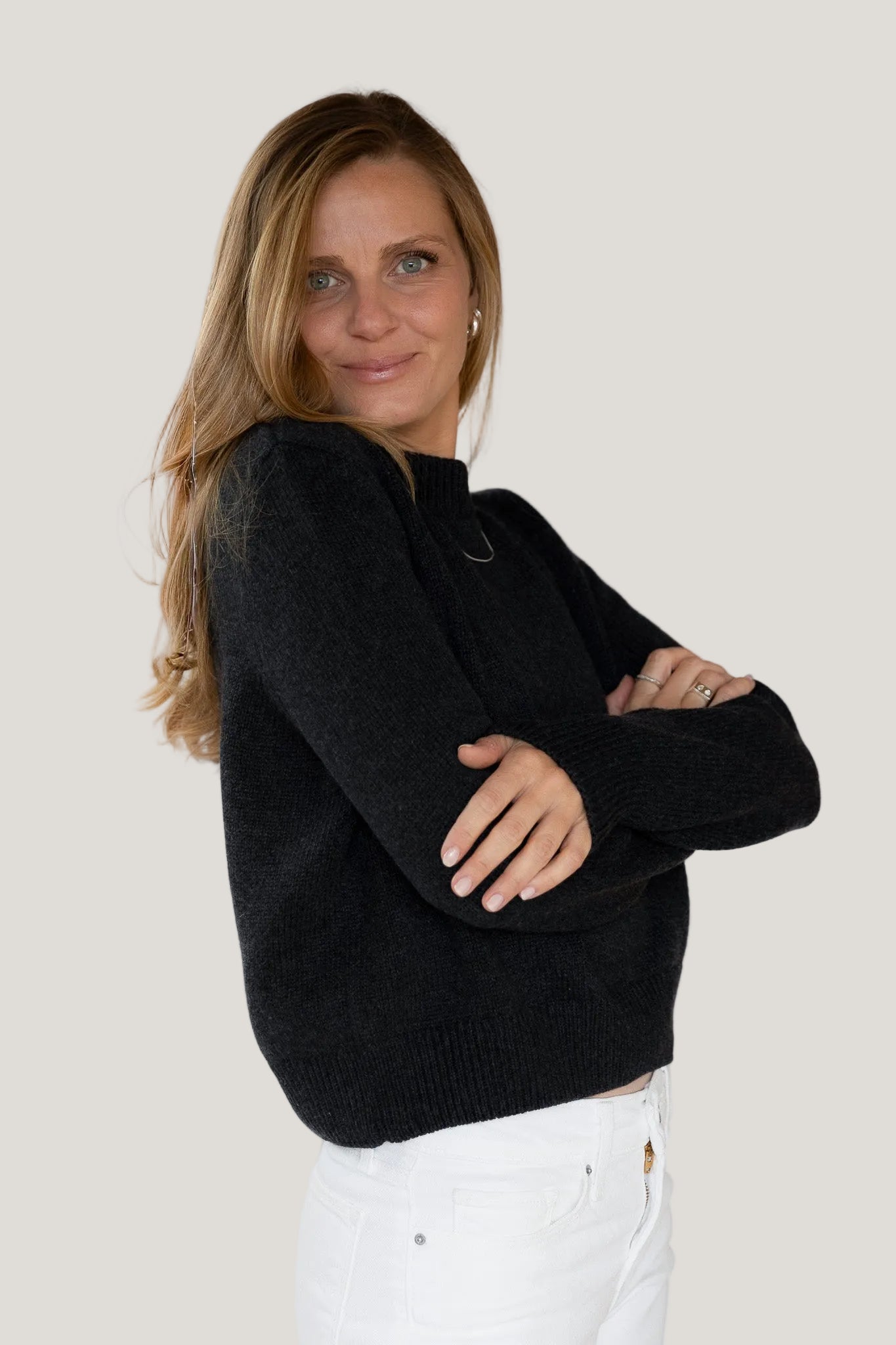 Woman wearing a black sweater against a white background