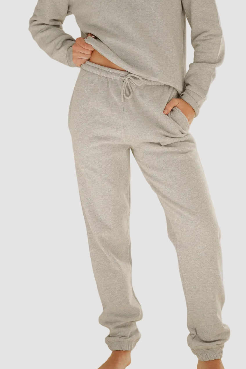 A person standing in a light grey, slightly baggy, brushed fabric pants with a drawstring waist.