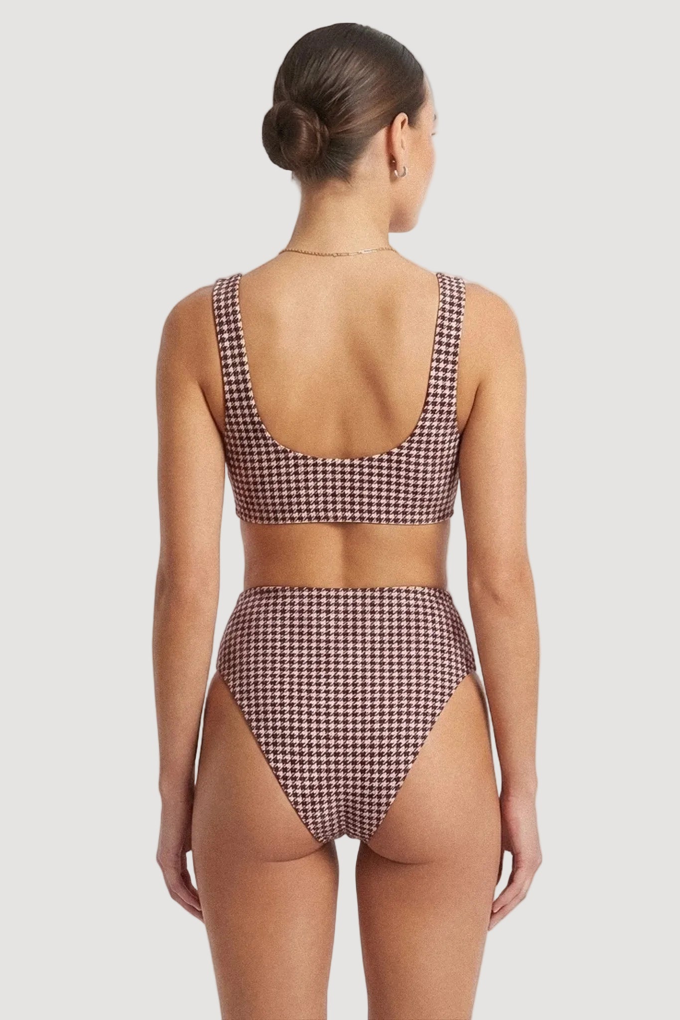 A woman shown from the back wearing a two-piece bikini with a burgundy and white houndstooth pattern against a plain white studio background.