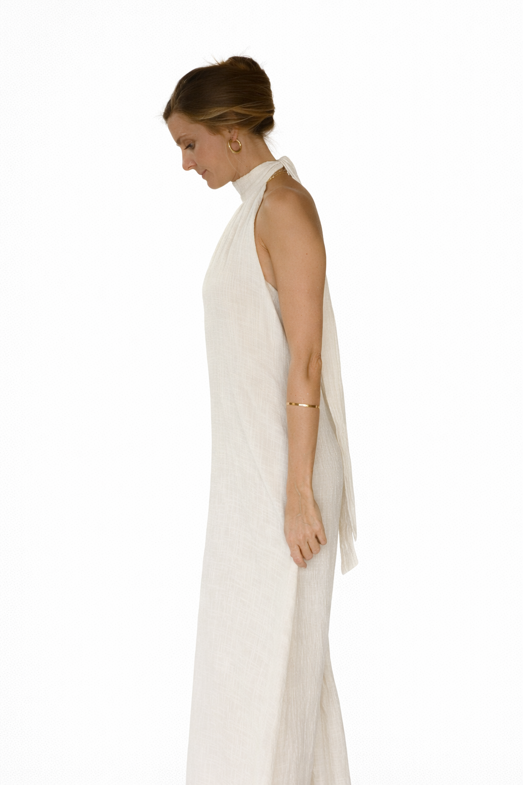 Woman wearing a white halter neck dress on a white background