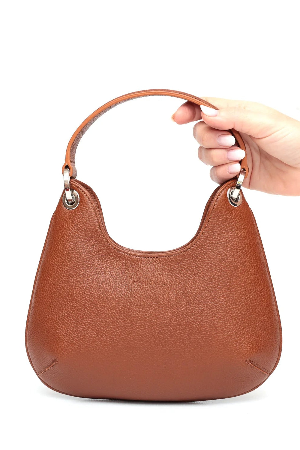 Brown handbag held by a hand on a white background