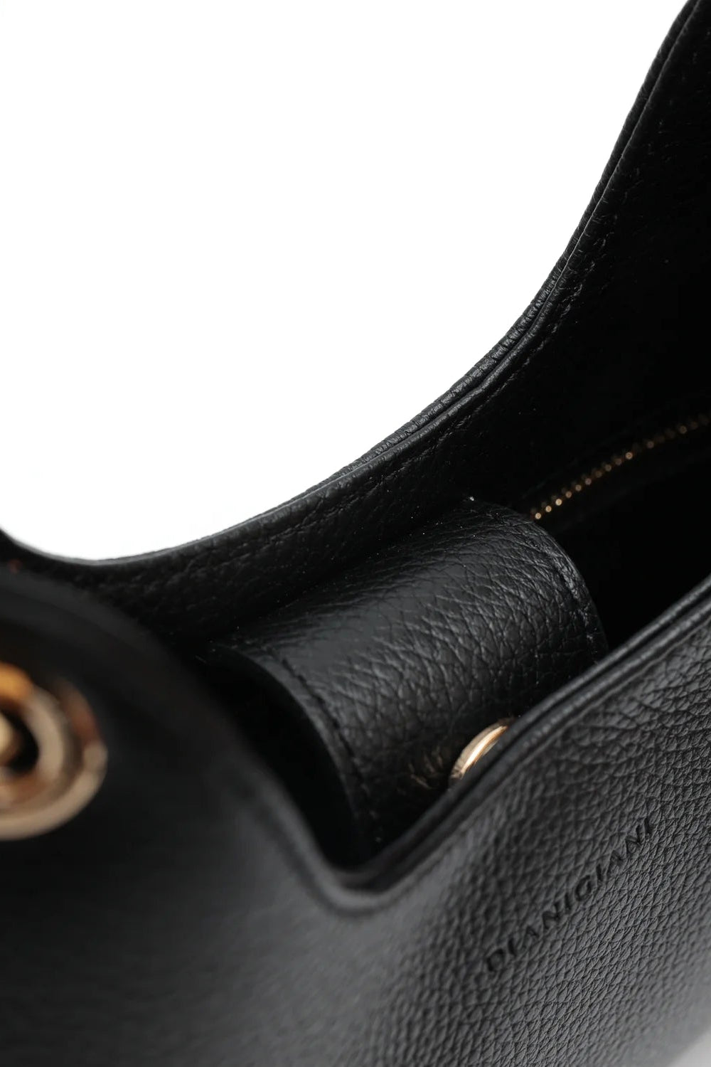 Close-up of a black handbag handle with gold hardware on a white background