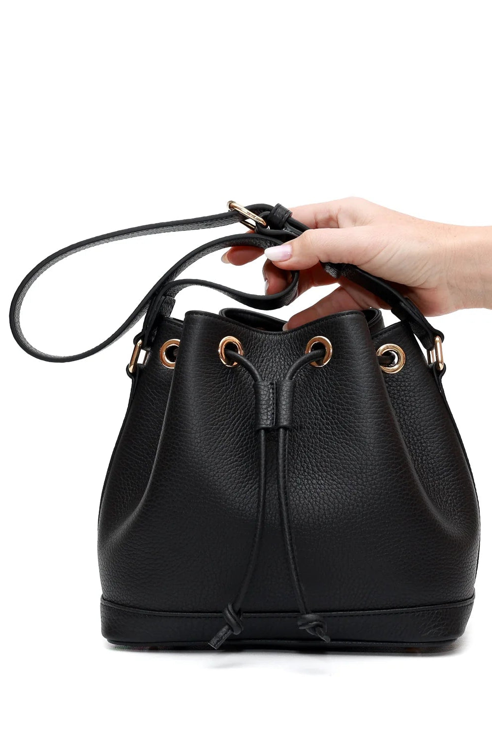 Black leather bucket bag held by a hand on a white background