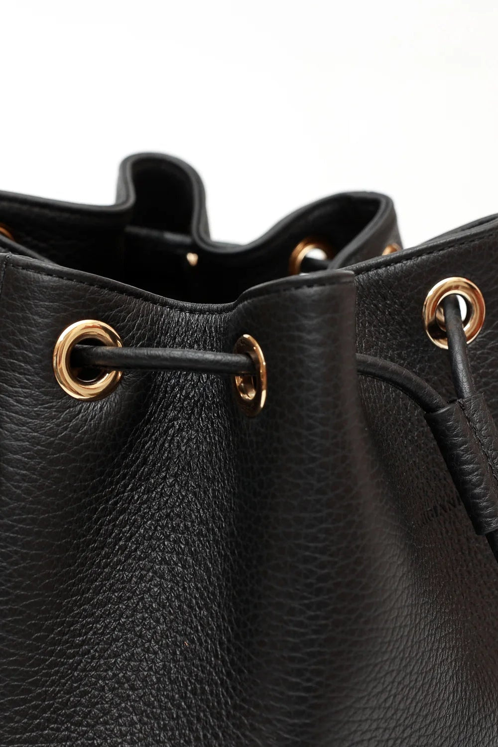 Black leather bucket bag with gold eyelets on a white background