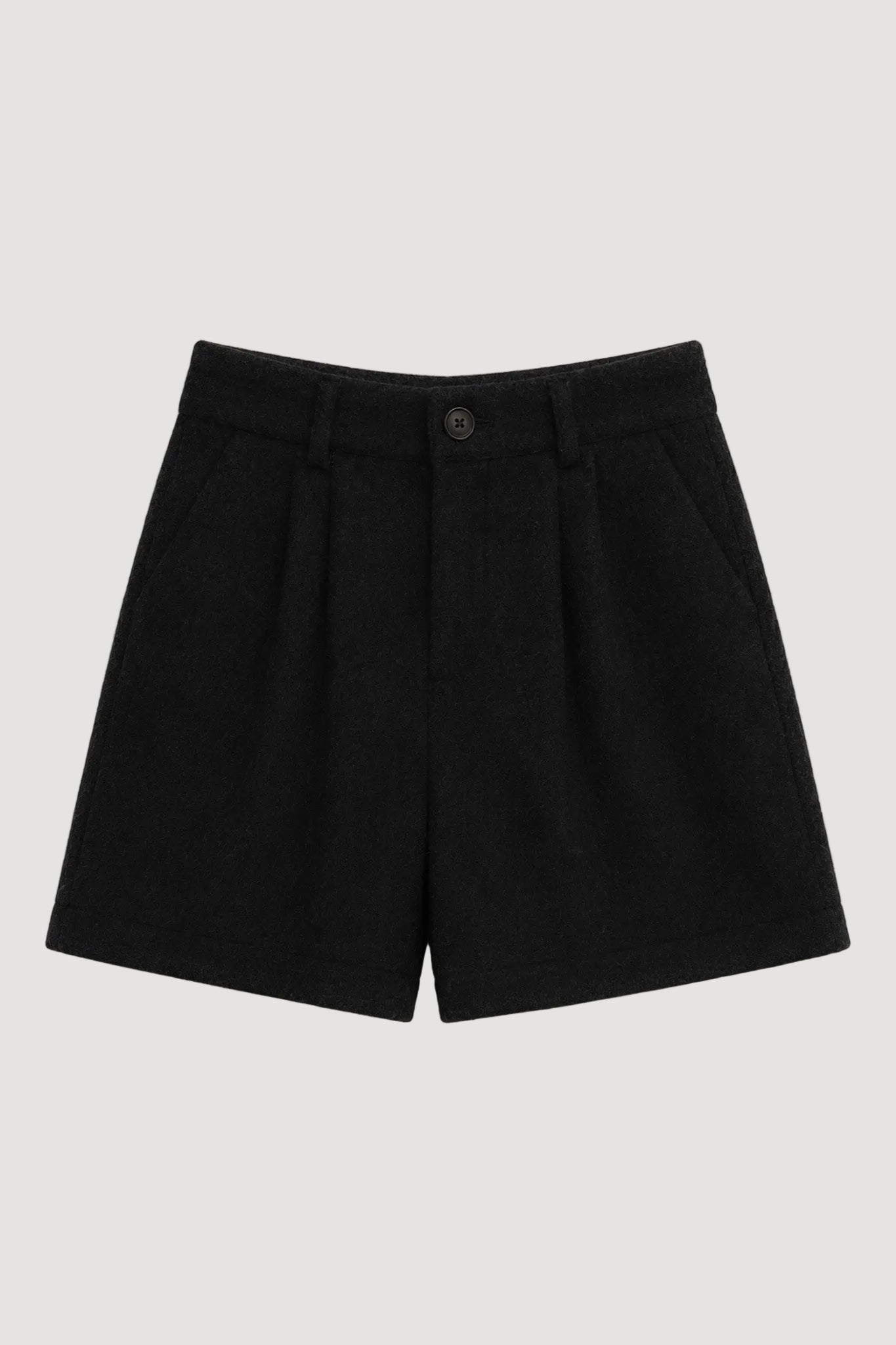 Black pleated wool shorts with a single button closure, laid flat on a light beige background.